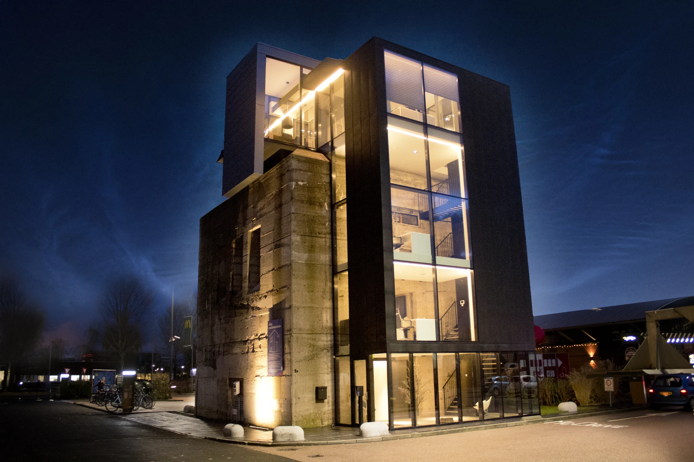 Het verlichte BNKR-gebouw in de avond